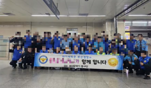 대규모 투자 사기 혐의로 수사 받고 있는 A사가 경찰들과 사기예방 캠페인 현수막을 들고 사진을 촬영 중이다. [독자 제공]